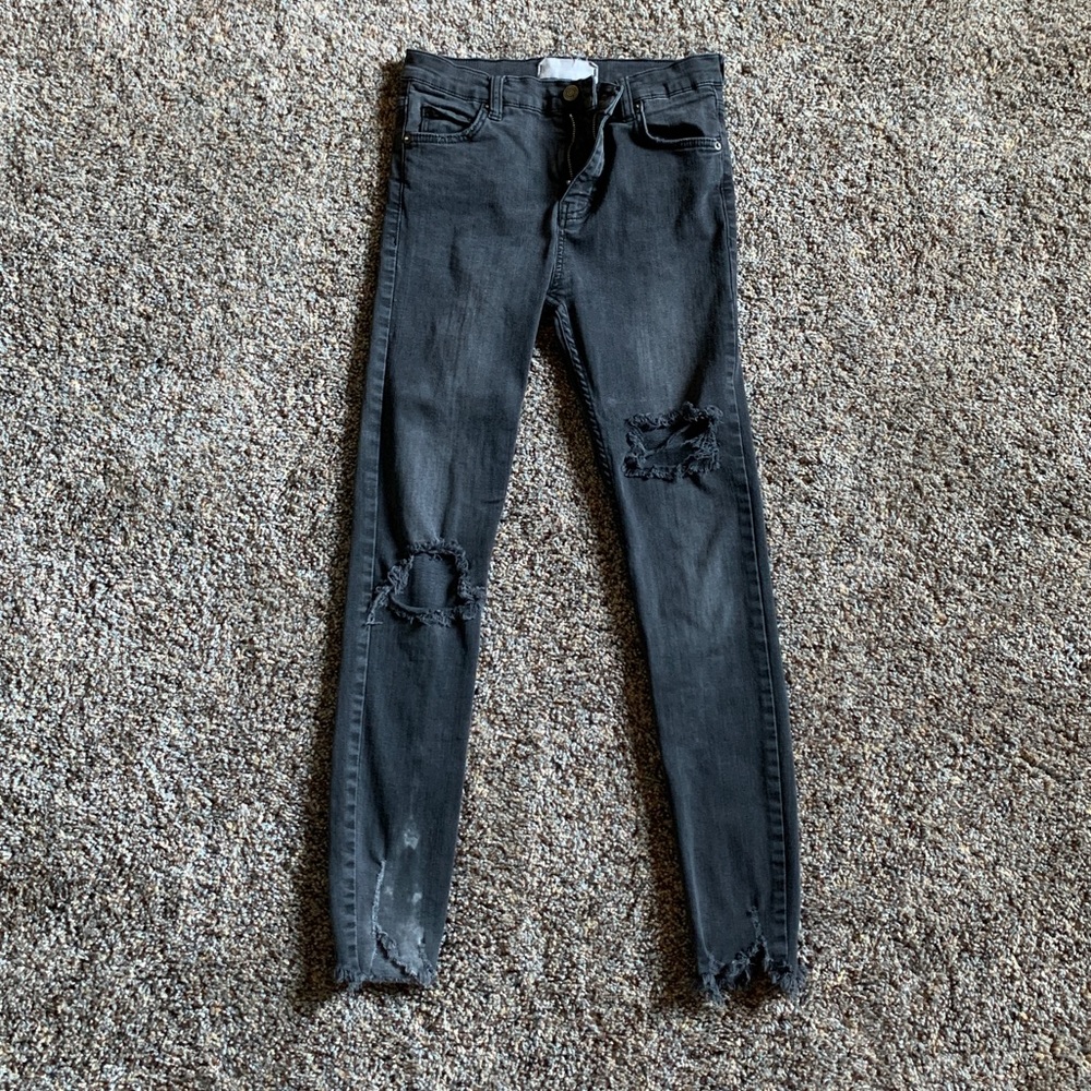 Distressed black jeans with ripped bottoms